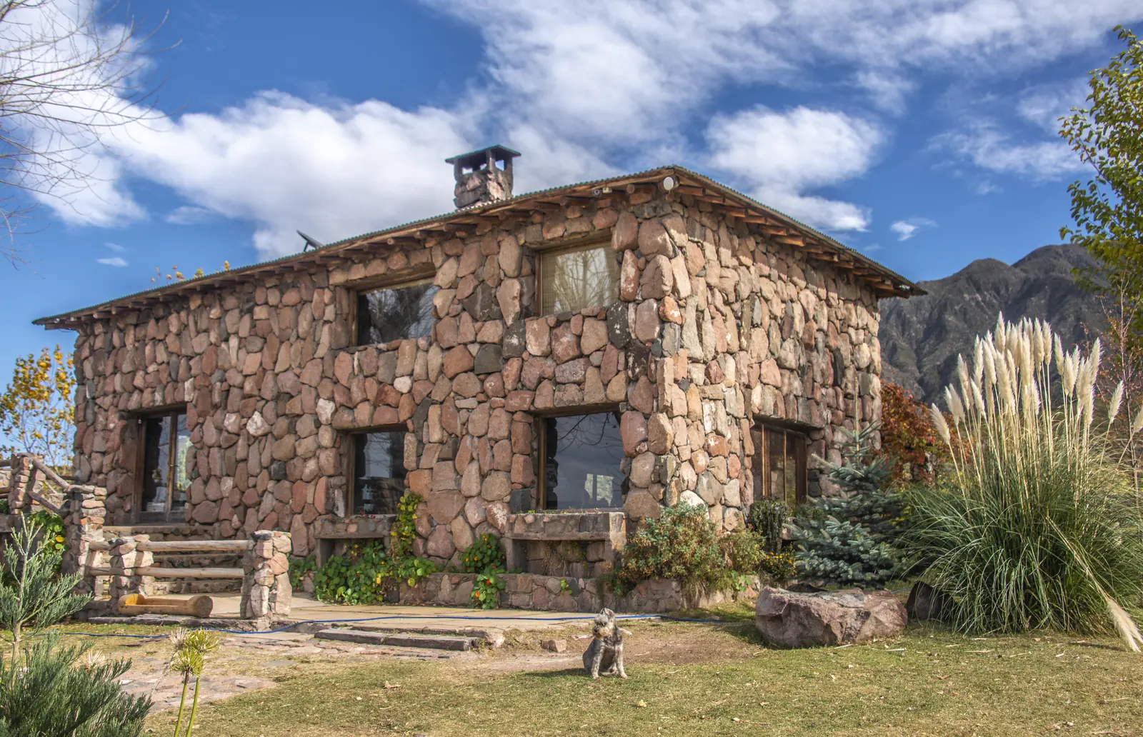 Casa de dos plantas construida con piedra de la zona, con la montaña de fondo