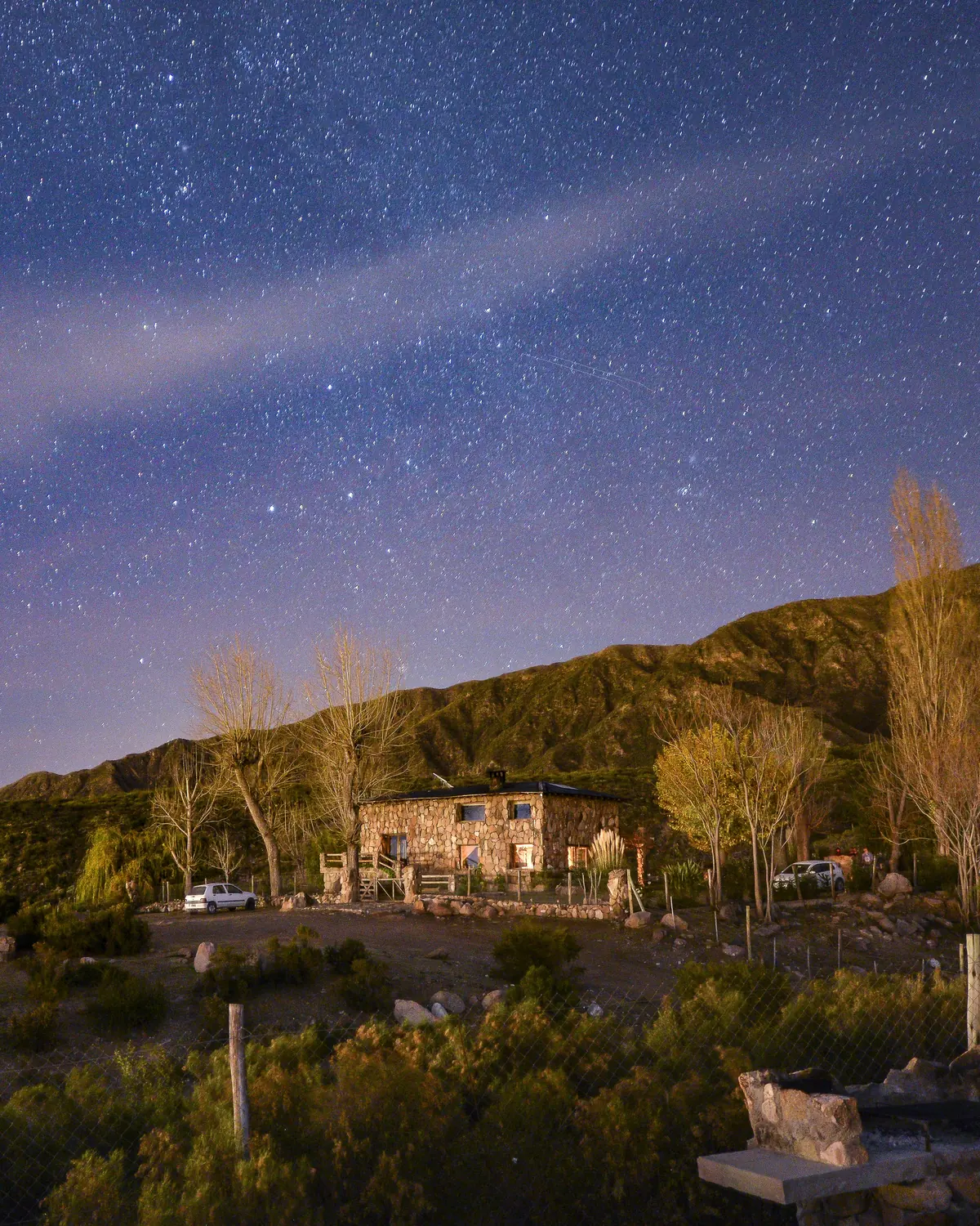 Casa de piedra iluminada bajo un cielo estrellado en La Crucesita